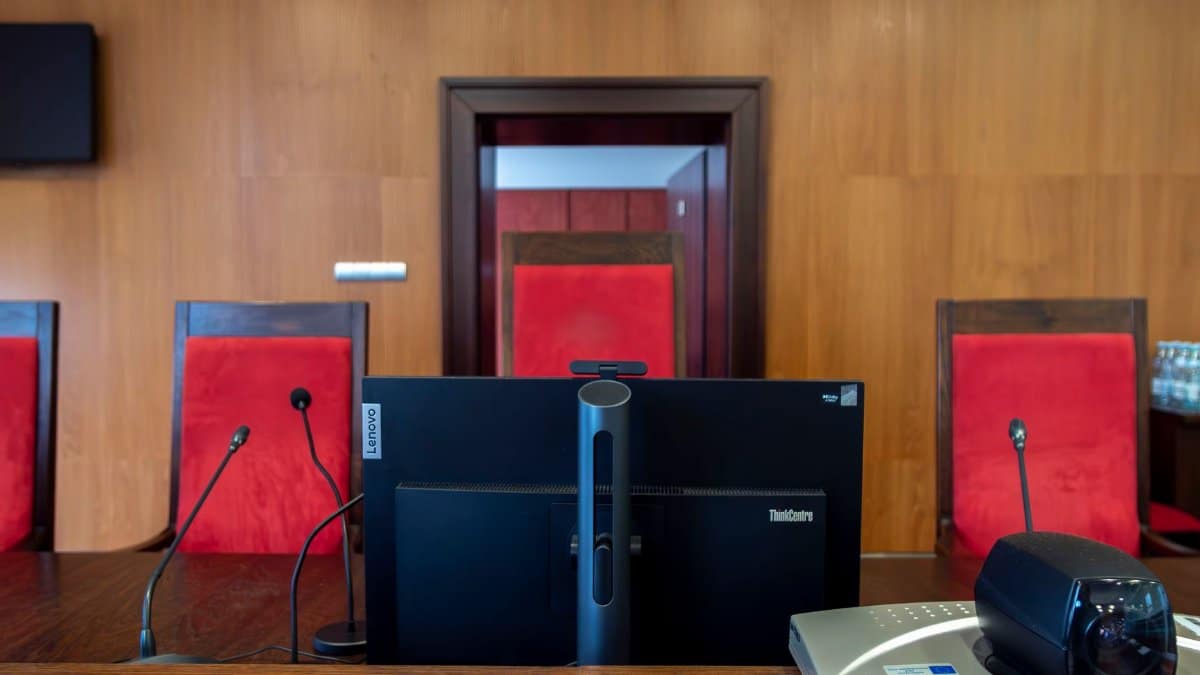 Modern courtroom interior in Wrocław, Poland featuring judge's bench and red seating.