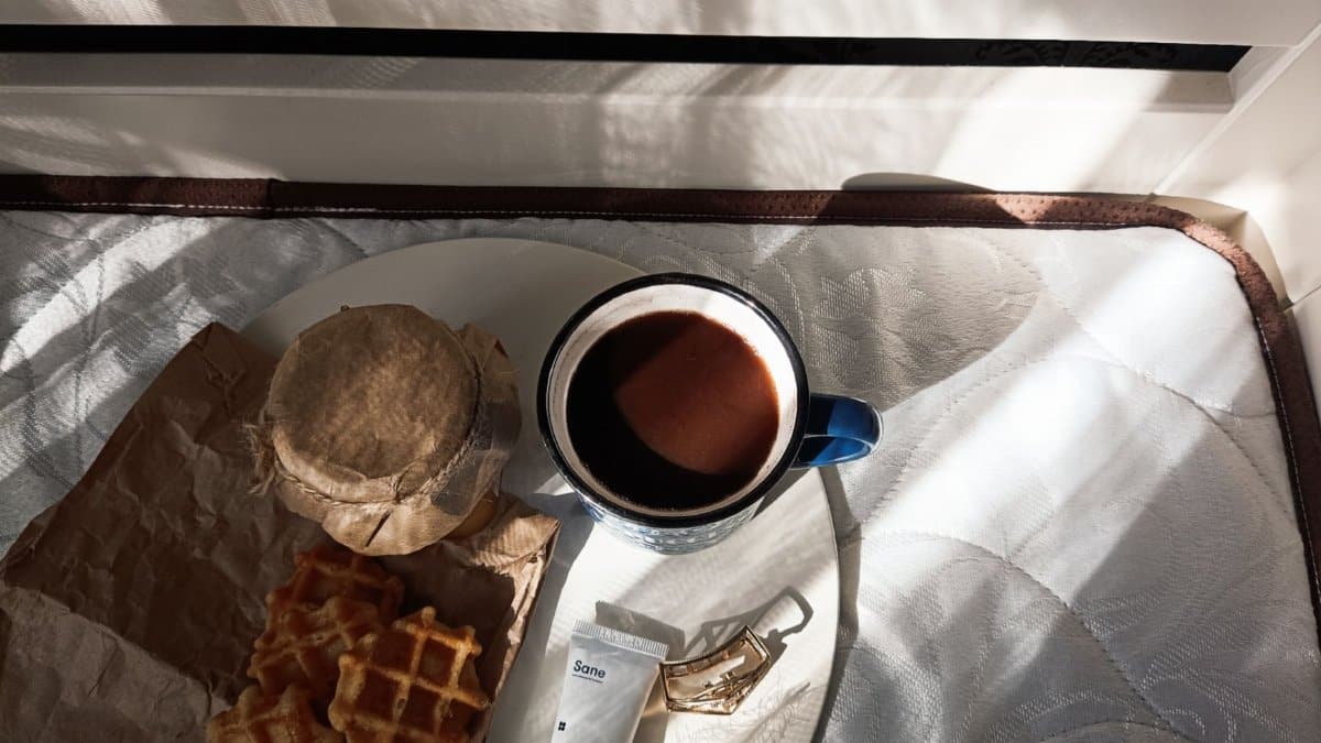 A cozy morning breakfast scene with coffee, waffles, and sunlight creating a serene atmosphere.