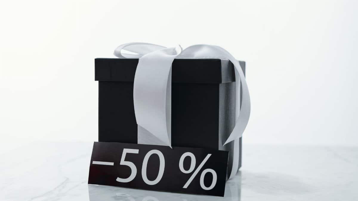 Elegant black gift box tied with a white ribbon, featuring a 50% discount tag.
