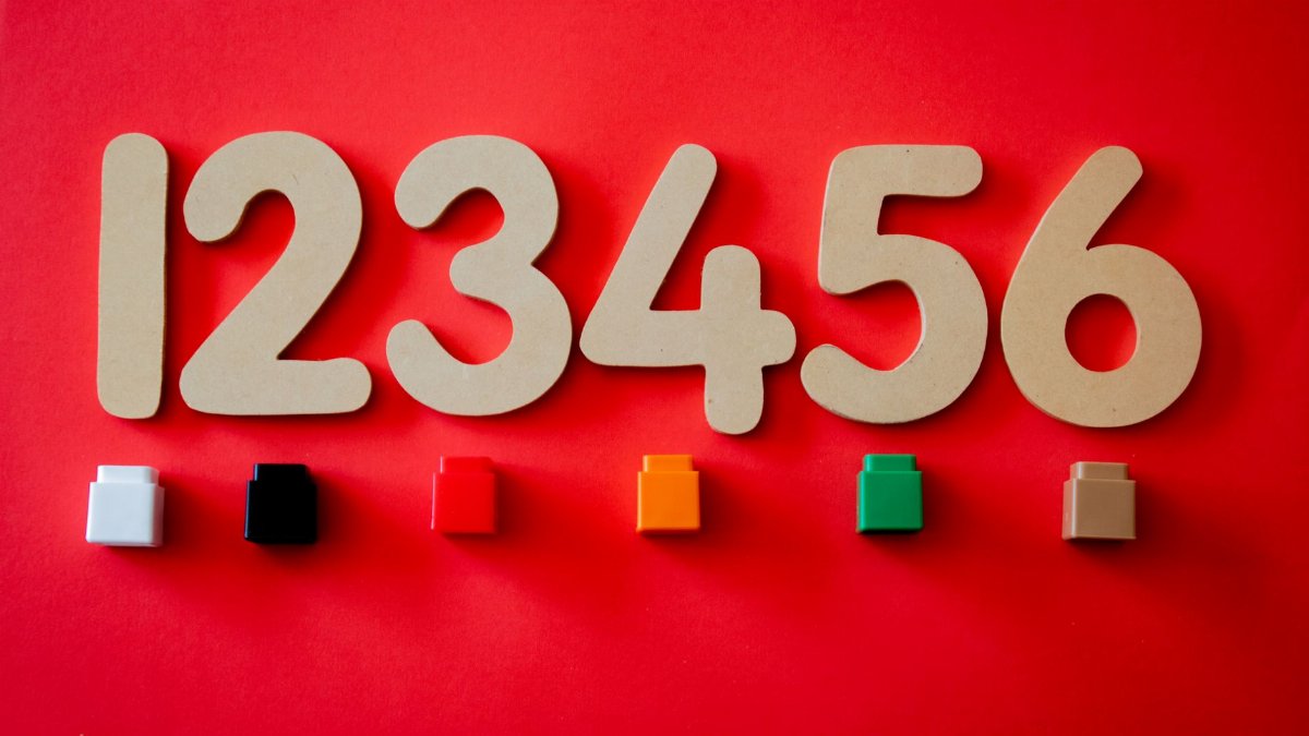 Wooden numbers with colorful blocks on vibrant red surface.