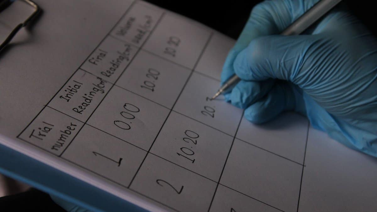 A scientist writes data on a clipboard during a laboratory experiment.
