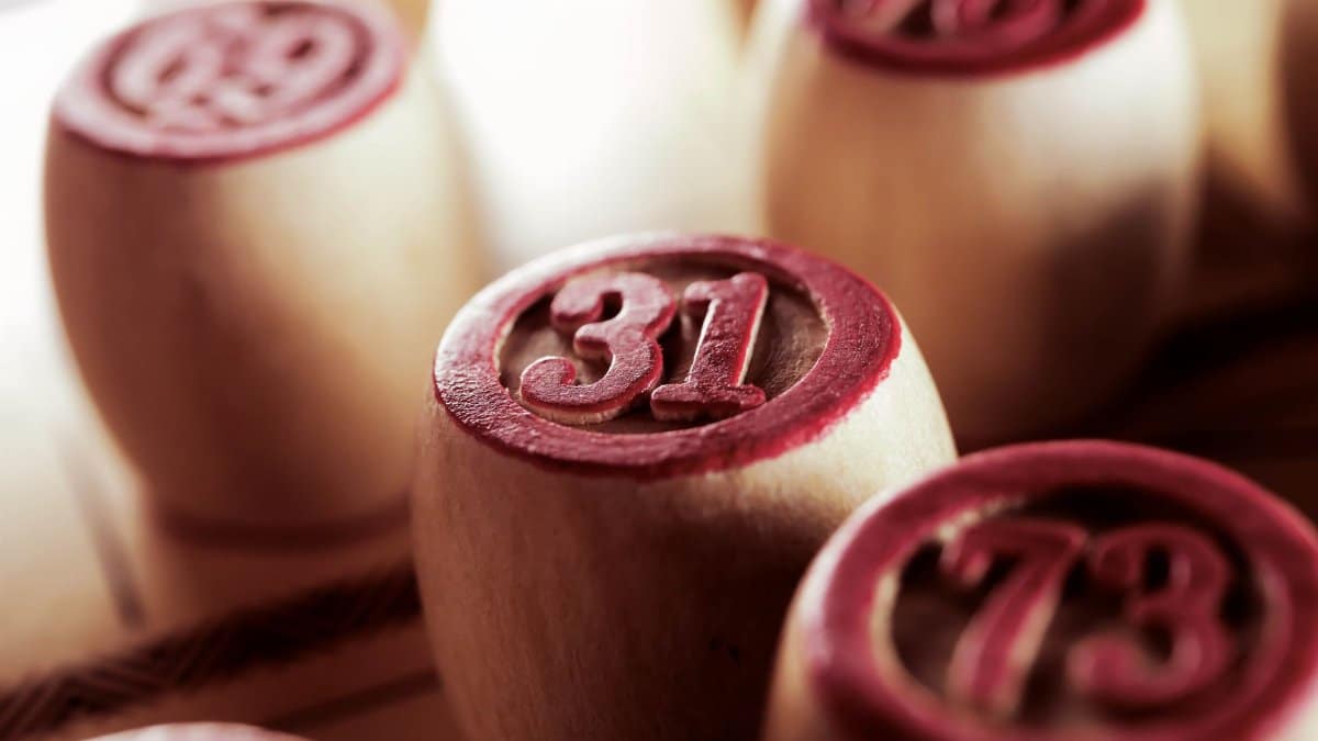 Wooden bingo game chips in focus, displaying numbers 31 and 73.