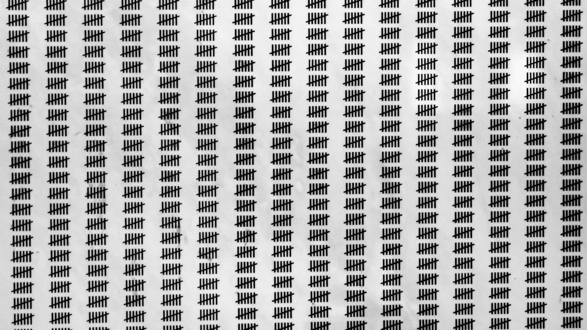 Repetitive tally mark pattern creating a visual texture on a white background.