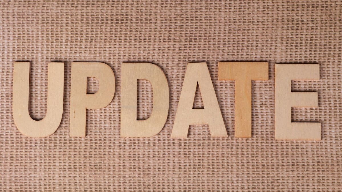 Wooden letters arranged to spell 'UPDATE' on a textured burlap surface, perfect for business or project imagery.