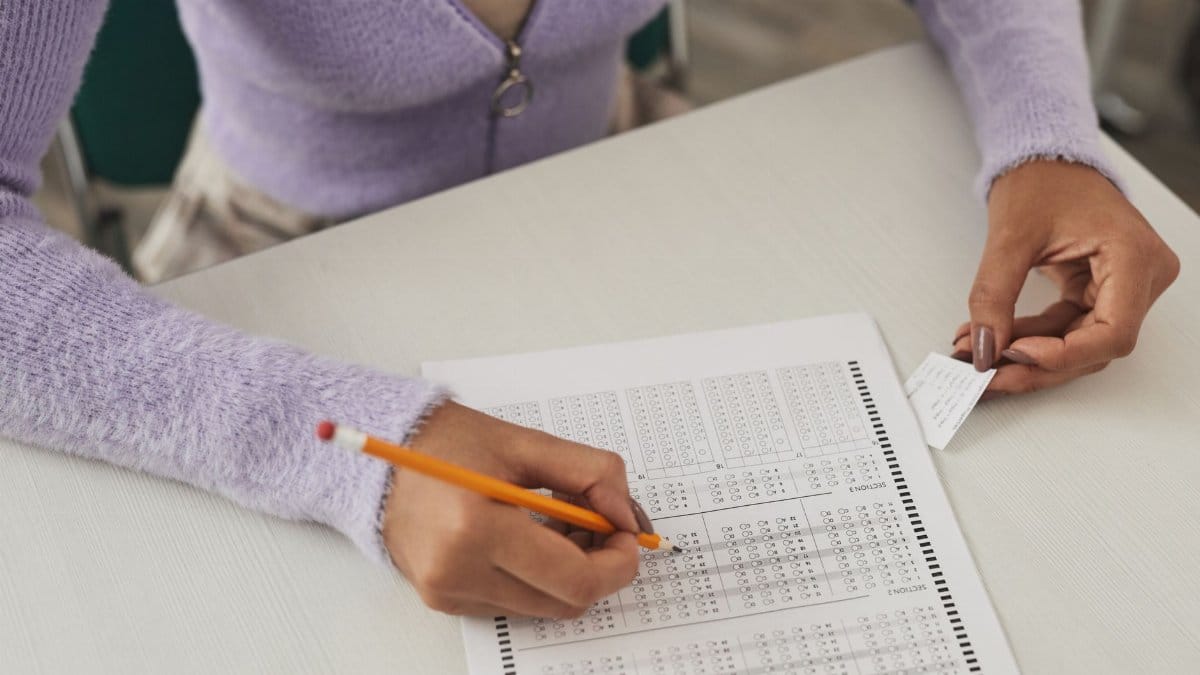 Close-up of a person using a cheat sheet while answering a multiple-choice exam.