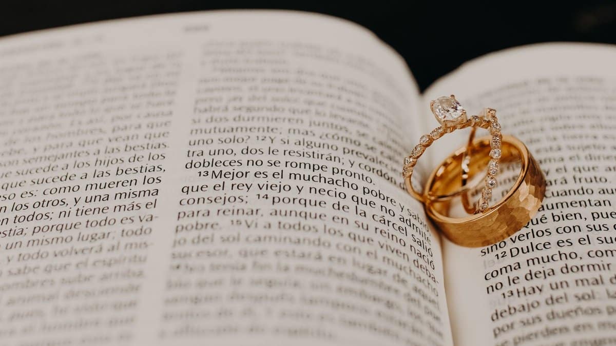 Close-up of wedding rings resting on an open book, symbolizing love and commitment.