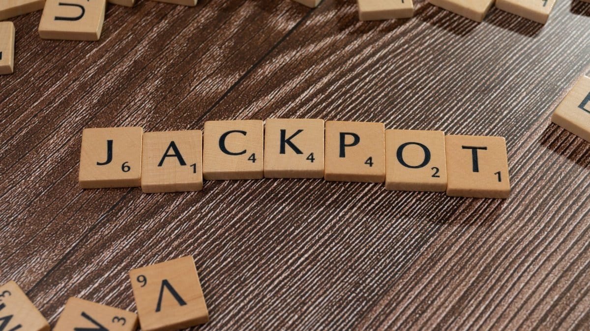 Wooden letter tiles spelling 'JACKPOT' on a textured wooden surface, representing winning or success.