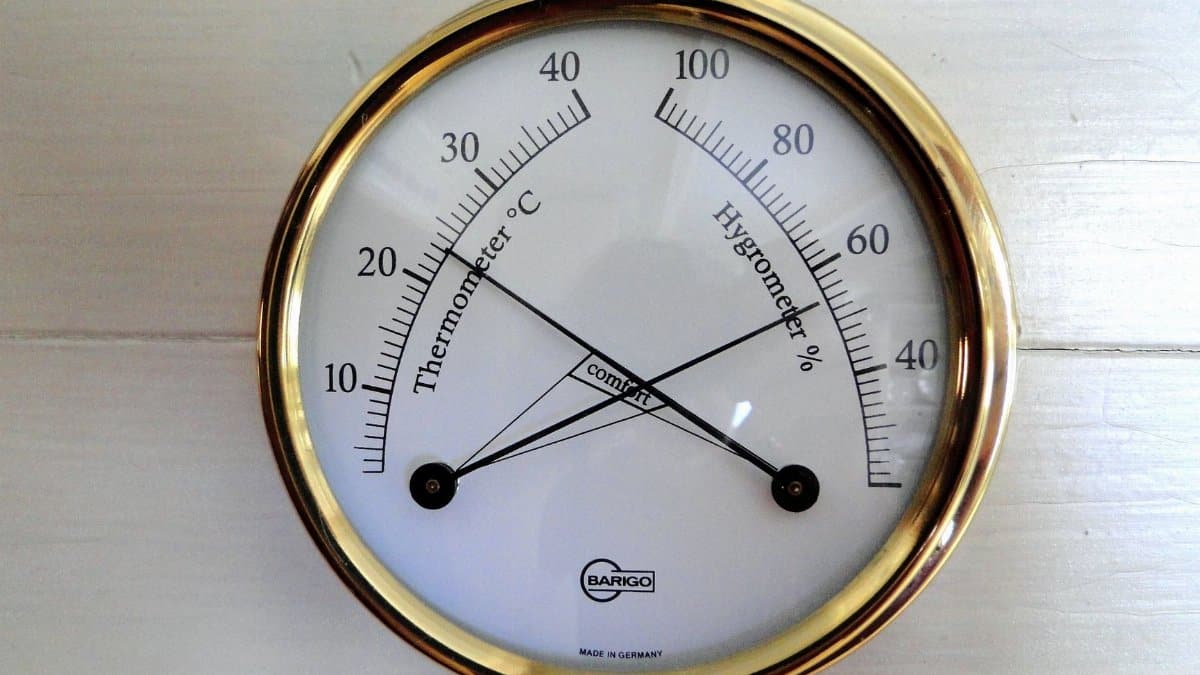 Close-up of a round analog display showing temperature and humidity.