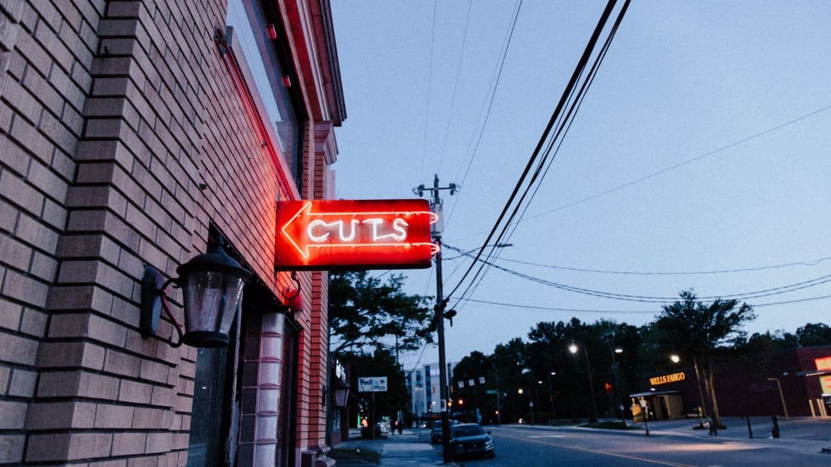 A neon sign reading 'Cuts' on a street corner in Durham, North Carolina.