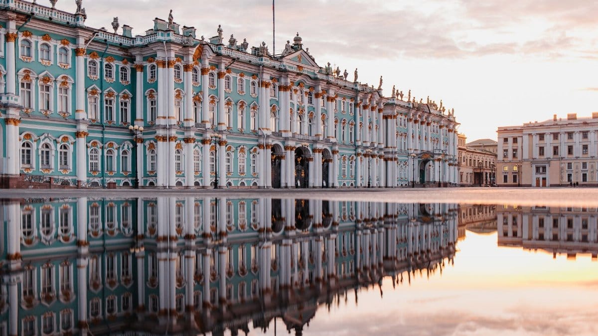 A stunning reflection of the Winter Palace in St. Petersburg, captured at sunrise in a serene puddle.