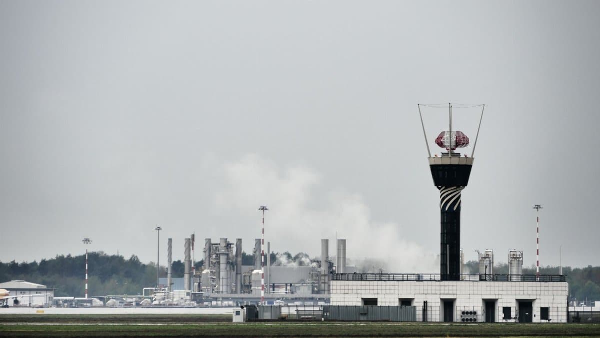 Control tower with industrial buildings in Lombardia, Italy, showcasing modern infrastructure.