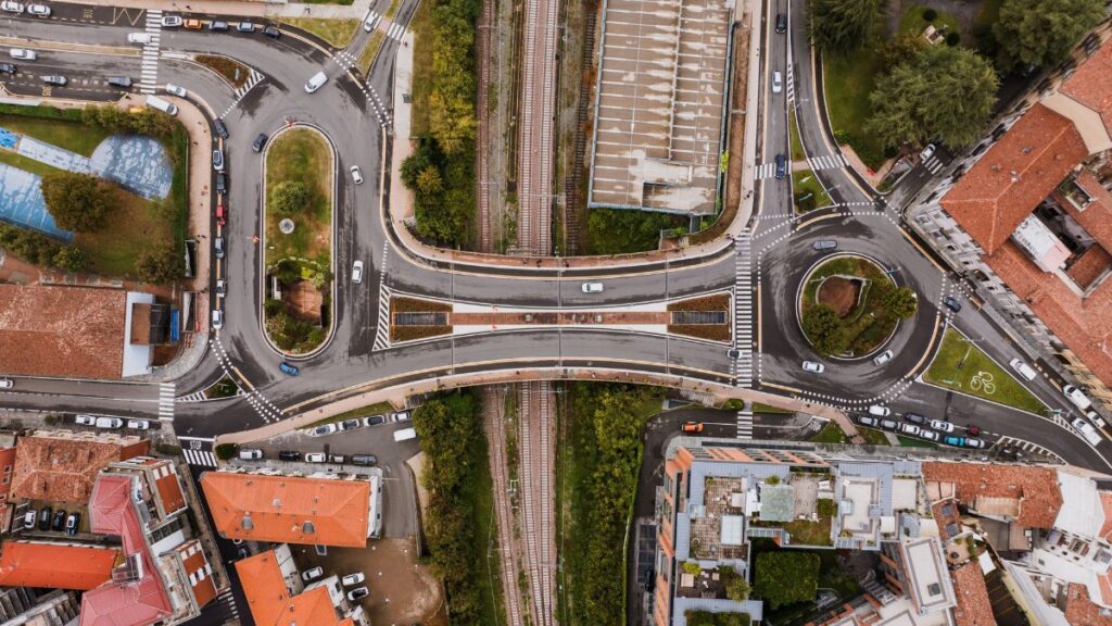 Aerial cityscape of Alba, Italy showcasing overpasses, roads, and railway tracks.