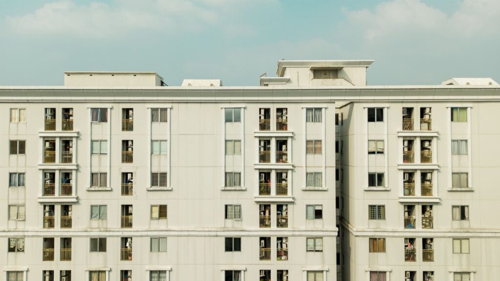 Detailed exterior view of a high-rise building with balconies and windows.