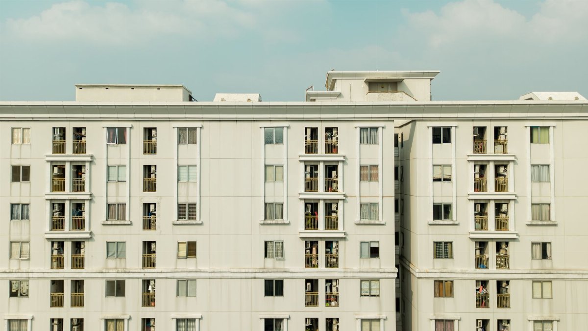 Detailed exterior view of a high-rise building with balconies and windows.