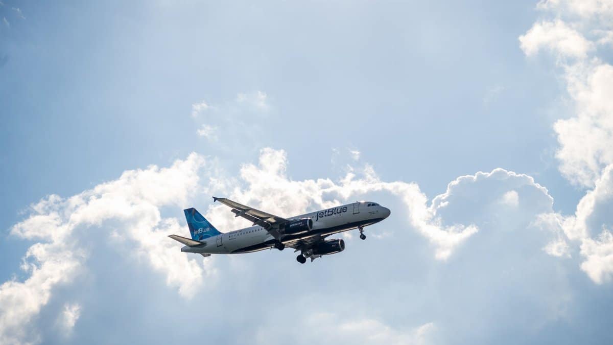 JetBlue Airbus A320 flying amidst fluffy clouds, a symbol of modern air travel.