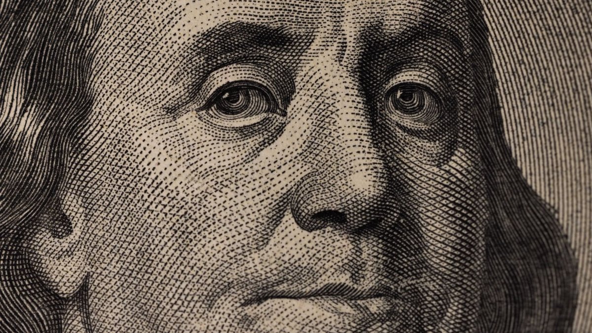 Detailed view of Benjamin Franklin's face on a US dollar bill, showcasing fine engraving.