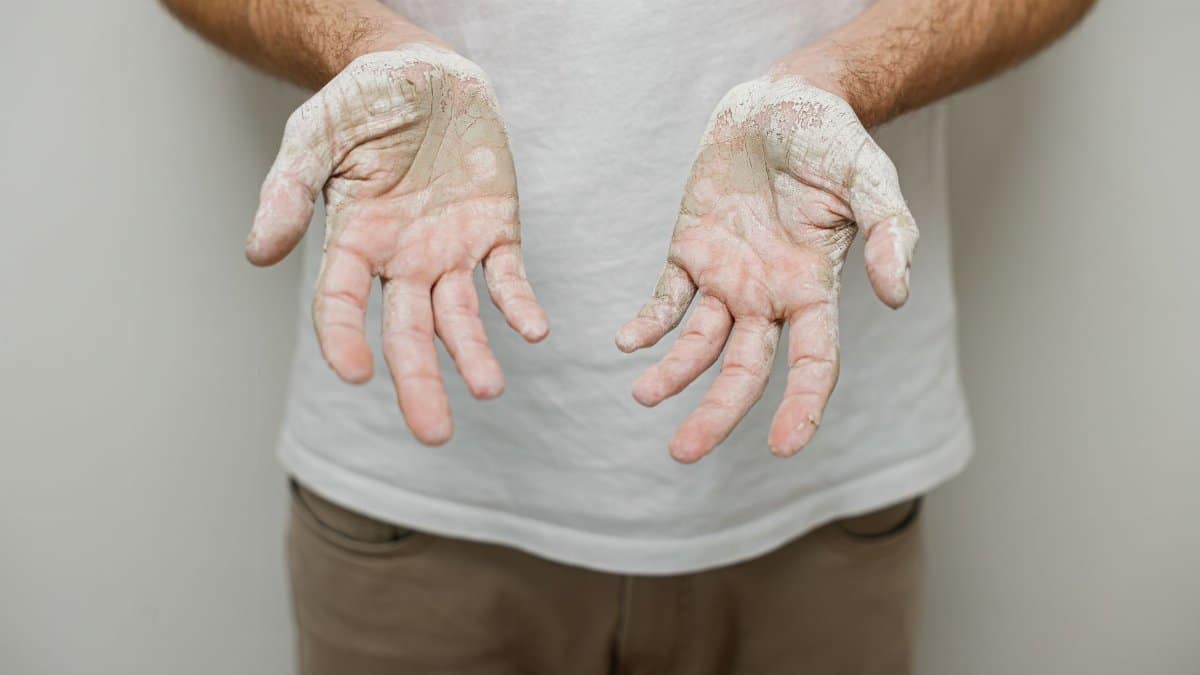 Close-up of a person's hands covered in white powder, conveying a concept of work or creativity.