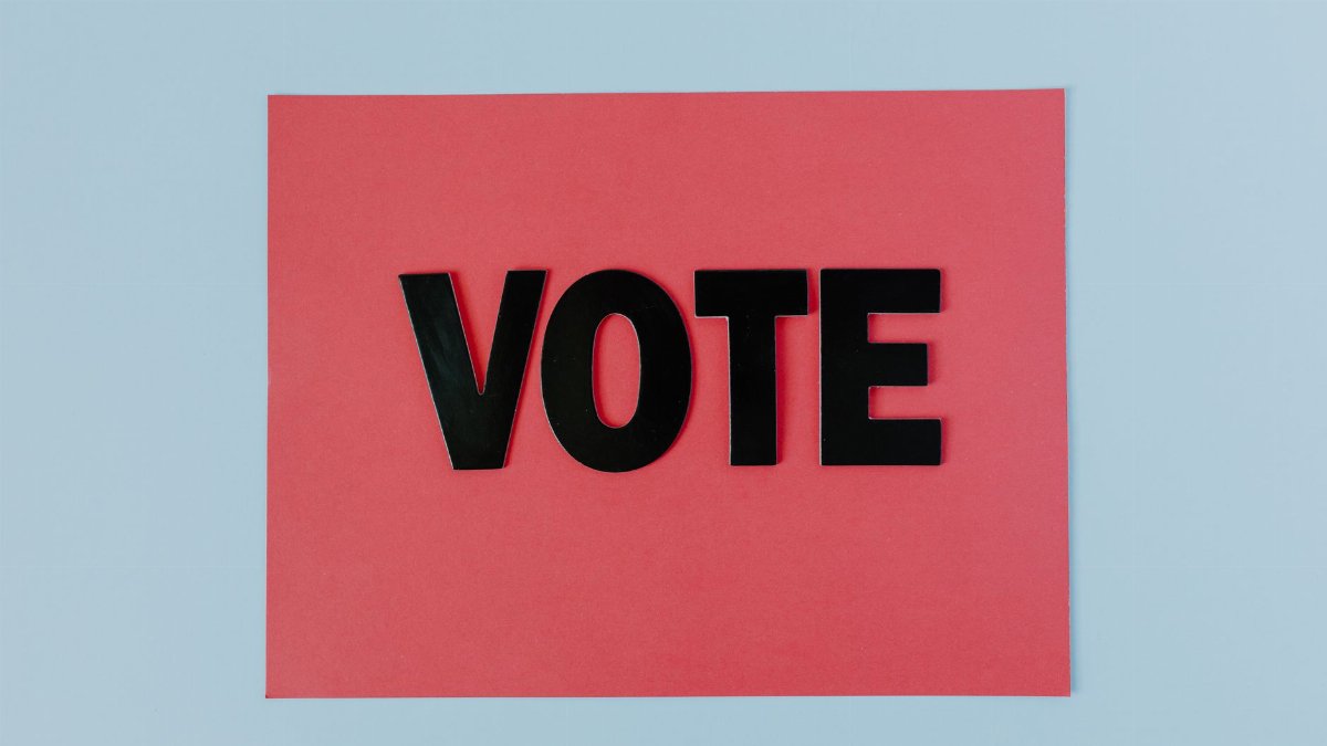 Black letters spelling 'VOTE' on red paper, emphasizing political participation.