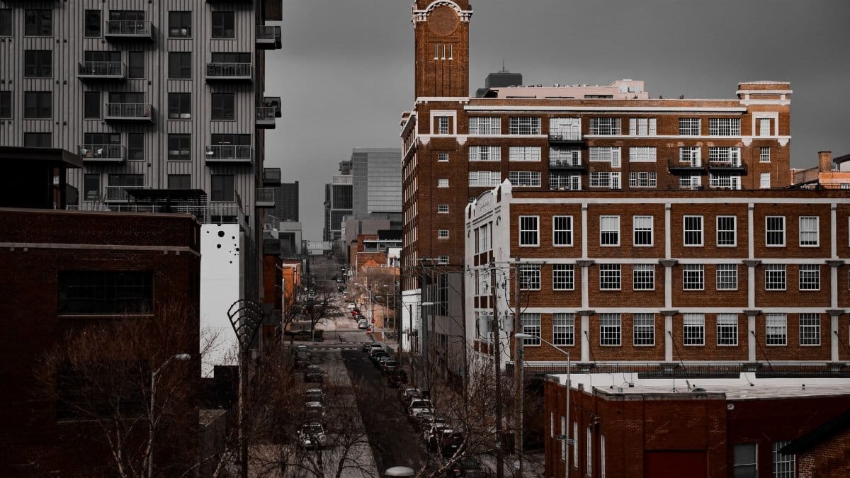 Explore the dense urban landscape of Kansas City, featuring historic brick architecture and modern apartment buildings on a cloudy day.