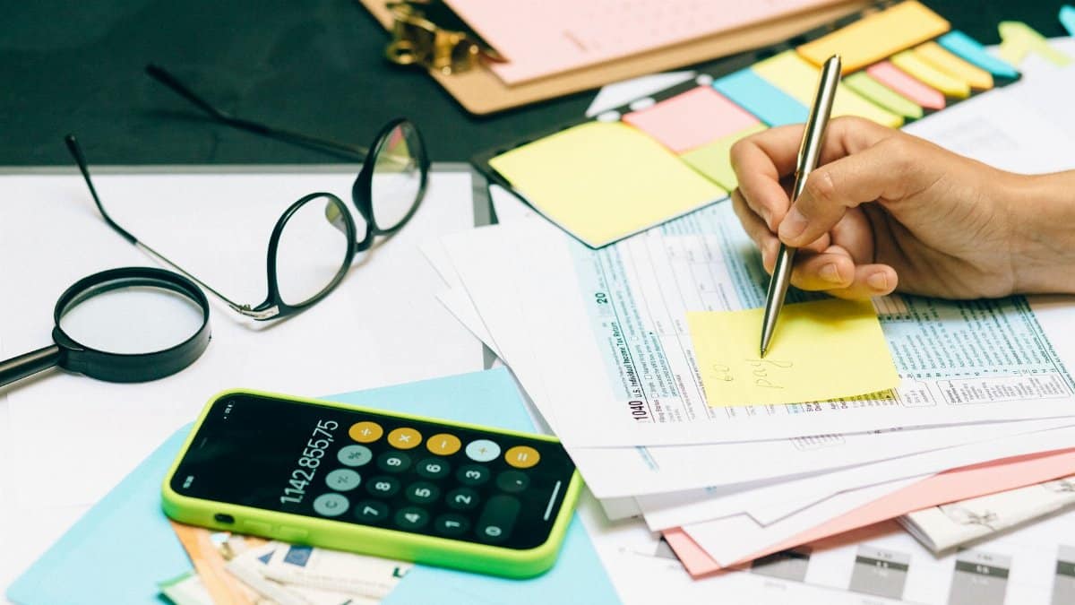Close-up of an office desk with a calculator, glasses, and documents for financial planning.