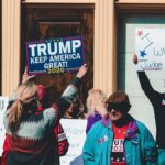 A group of people at a political rally in Wheeling, West Virginia, supporting different 2020 election campaigns.
