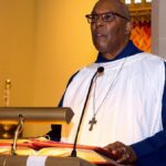 Pastor delivering a sermon in a church, emphasizing religious practice and spirituality.