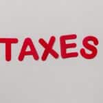 Simple and bold image of the word taxes in red letters on a white background.