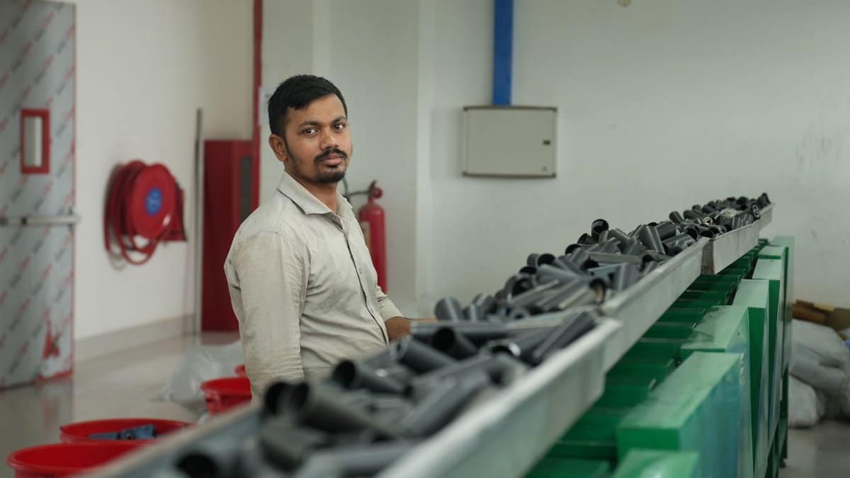 A factory worker oversees the operation of a conveyor belt transporting materials.