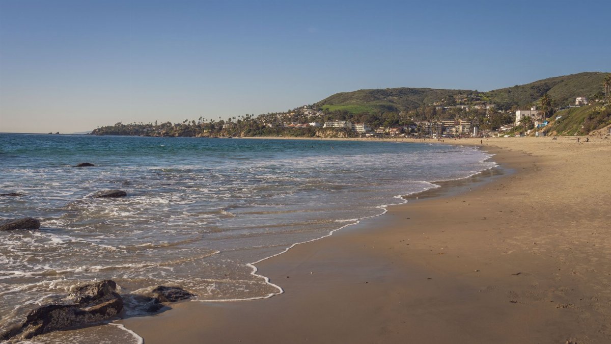 A picturesque view of Laguna Beach with clear skies and gentle waves.