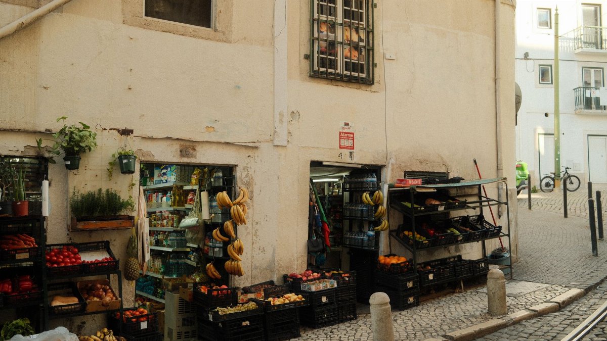 A cozy street market in Lisbon displaying vibrant fruits and vegetables outdoors.
