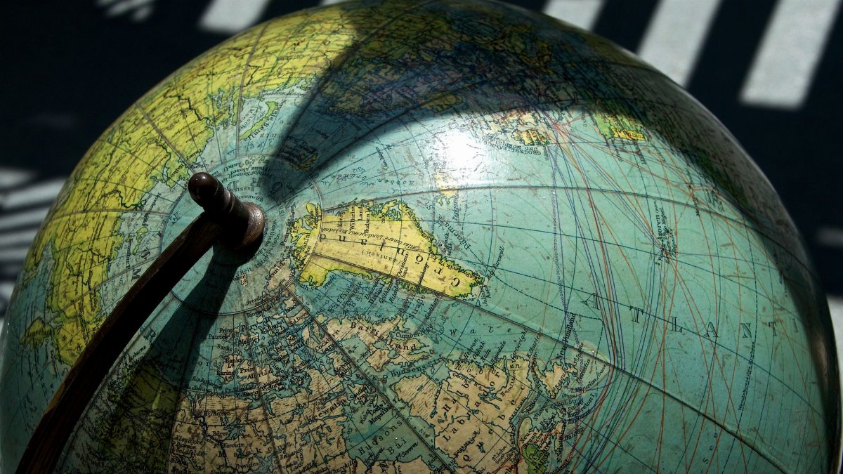 A detailed vintage globe showcasing northern regions with visible longitude and latitude lines.