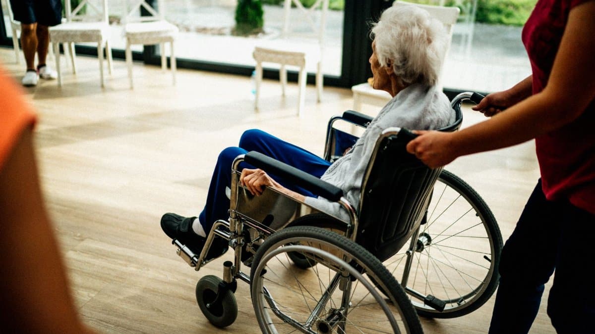 A caregiver assists a senior adult in a wheelchair at a nursing home in Prague, Czech Republic.