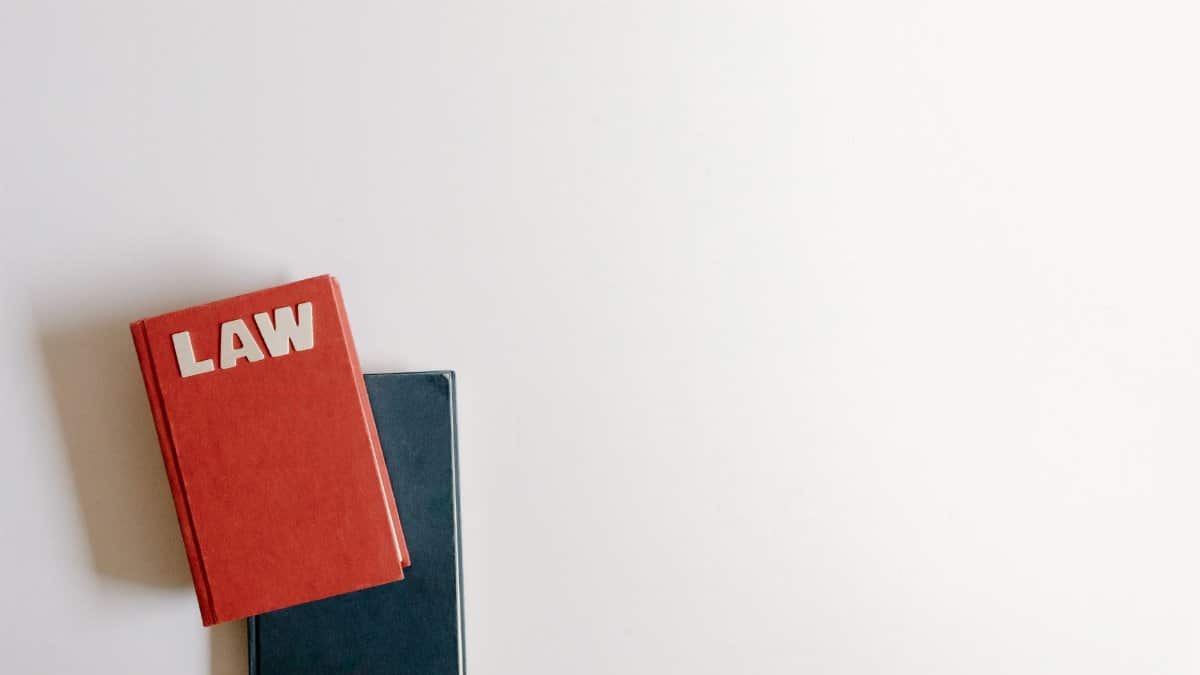Flat lay of a red law book and a blue book on a white background, perfect for legal themes.