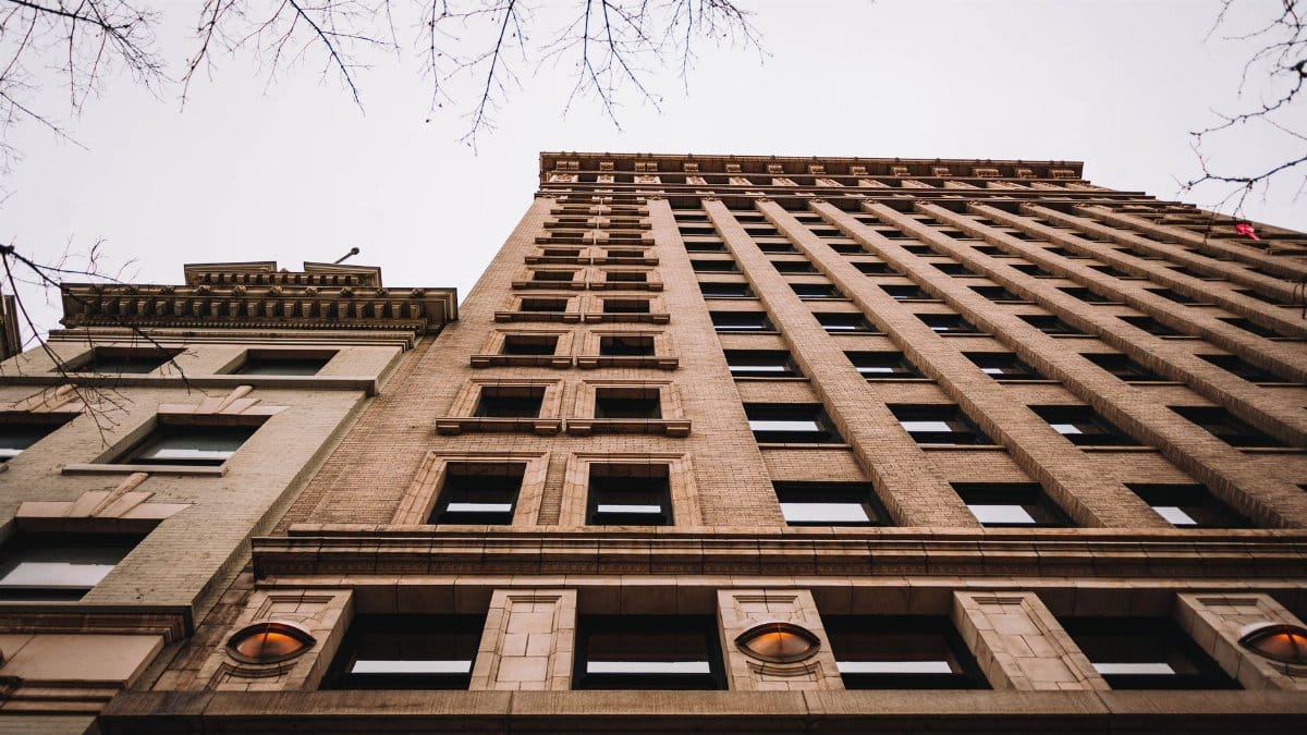 Dramatic low angle view of a historic urban building against a cloudy sky.