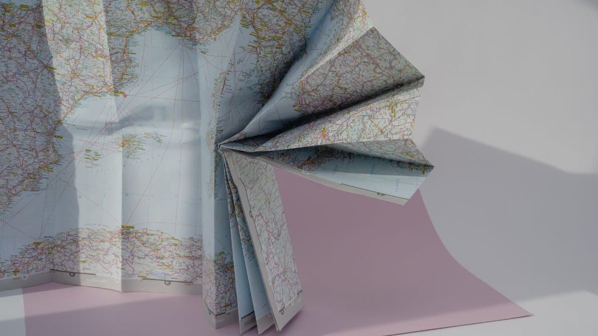 A creatively folded world map displayed in soft lighting, perfect for travel-related themes.