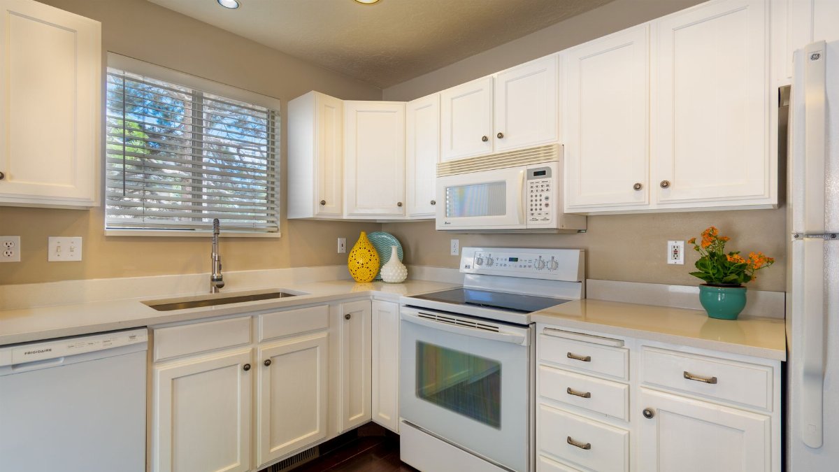 Bright and clean white kitchen featuring modern appliances and sleek design.