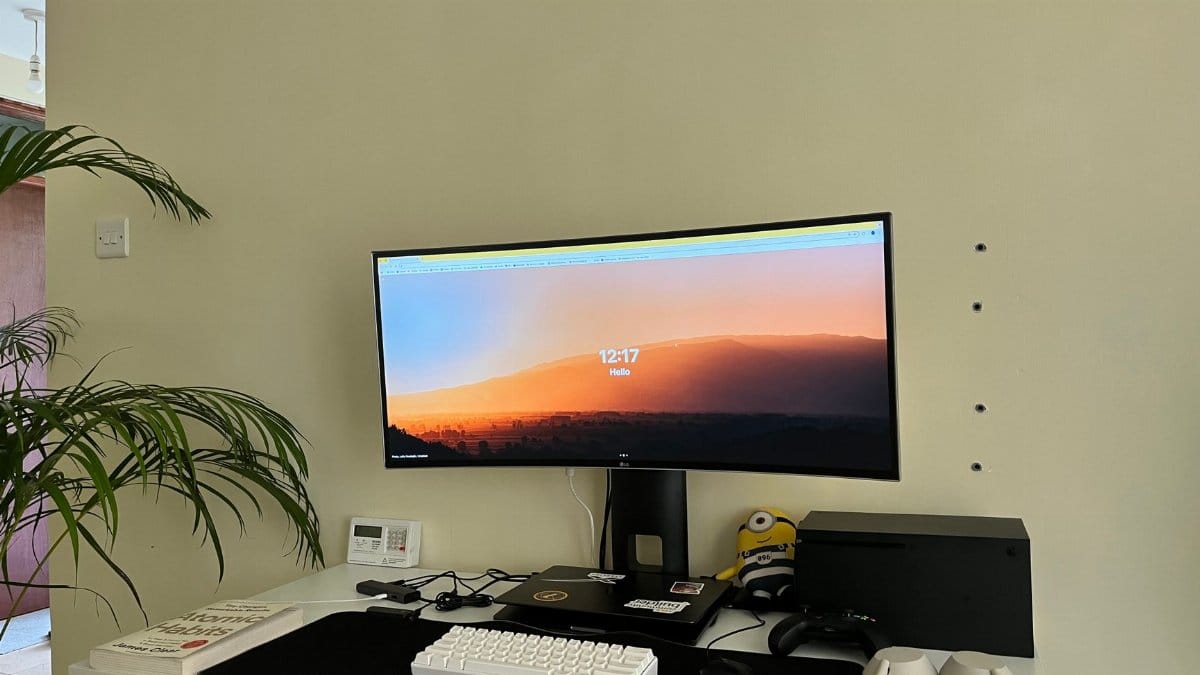 A modern home office setup in Nairobi with a curved monitor, desk, and accessories.