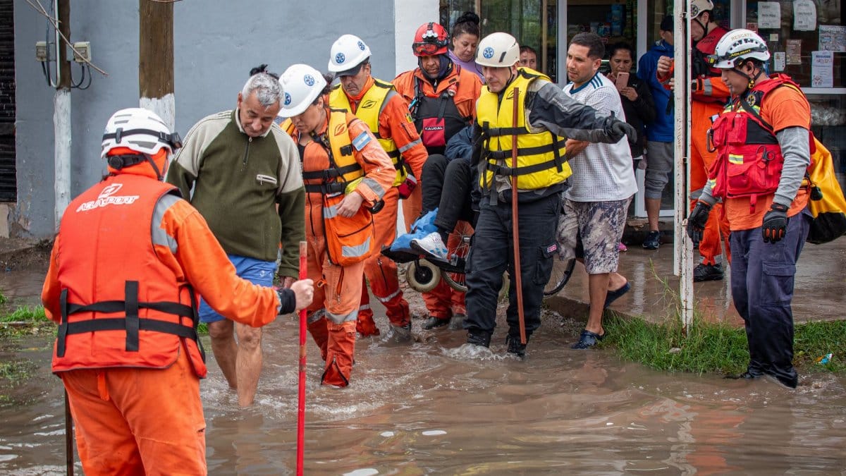 Emergency responders help people during a street flood rescue operation.