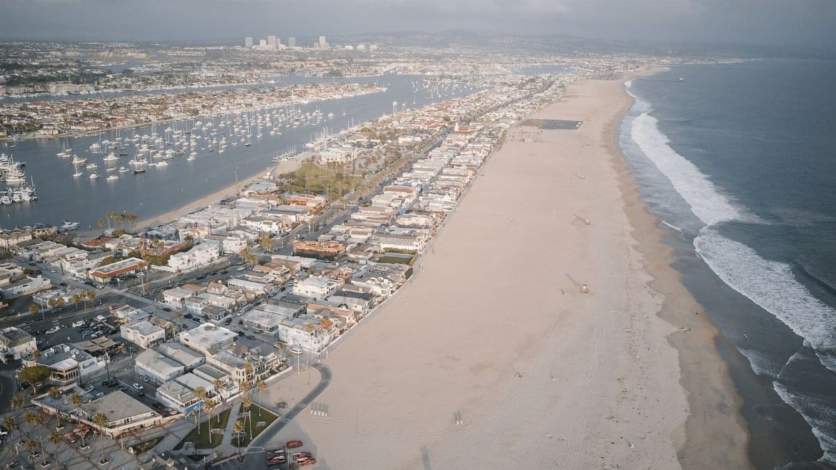 A stunning aerial view showcasing a coastal city with a vast beach and calm seashores.