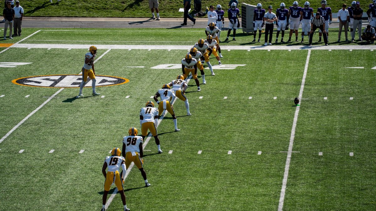 Aerial shot of an American football game kickoff with players in action.