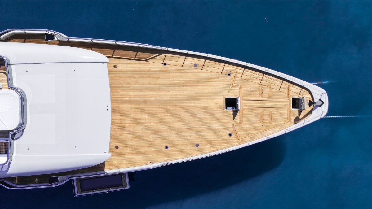Top-down view of a sleek luxury yacht cruising in the vibrant blue waters of Malta.