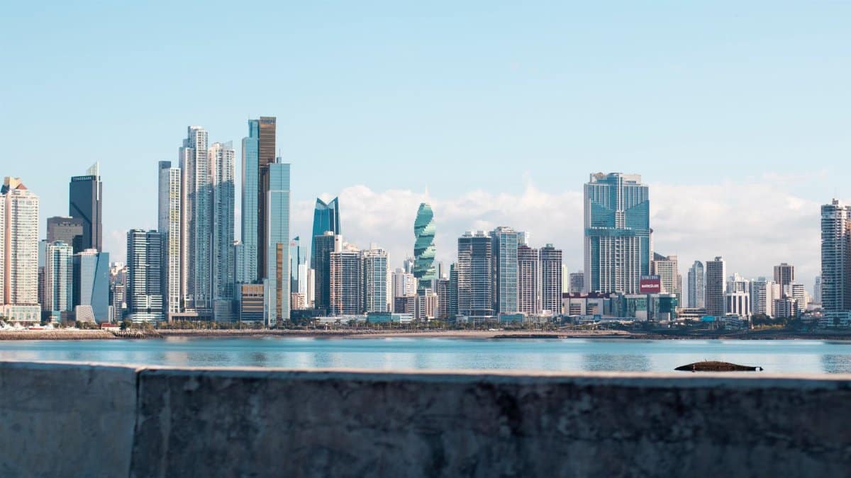 Panama City skyline under clear blue sky, viewed from waterfront showing iconic skyscrapers.
