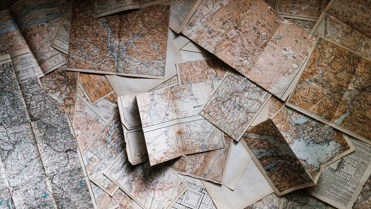 A collection of vintage maps scattered for exploring world journeys and discoveries.