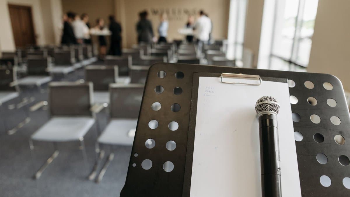 Close-up of a microphone on a stand in a conference room setting.