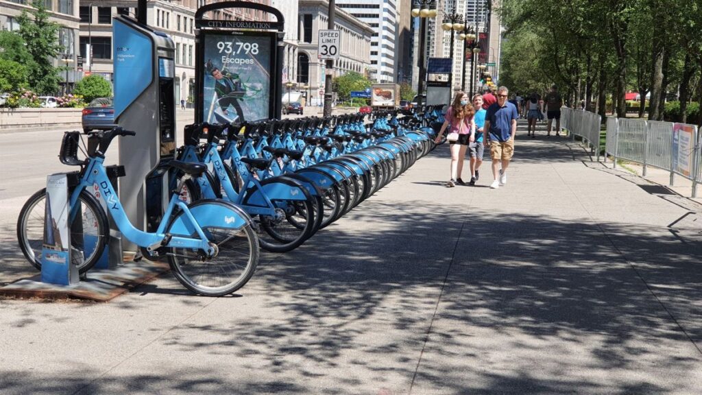 A bustling bike share station in downtown Chicago on a sunny day.