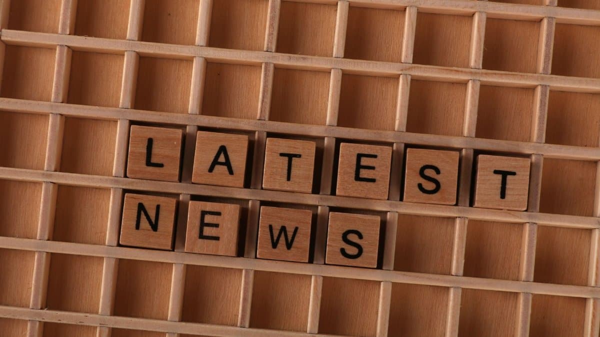 Wooden letter blocks spelling Latest News on a grid background, ideal for media themes.