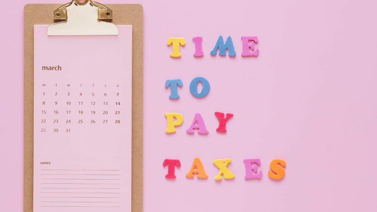 Colorful tax reminder on clipboard against a pink background for March