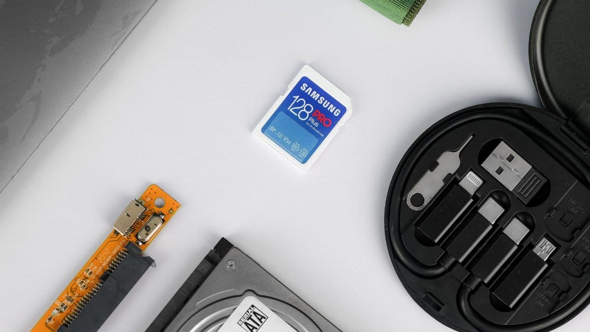 Flat lay of various technical components including a memory card and hard drive on a white background.