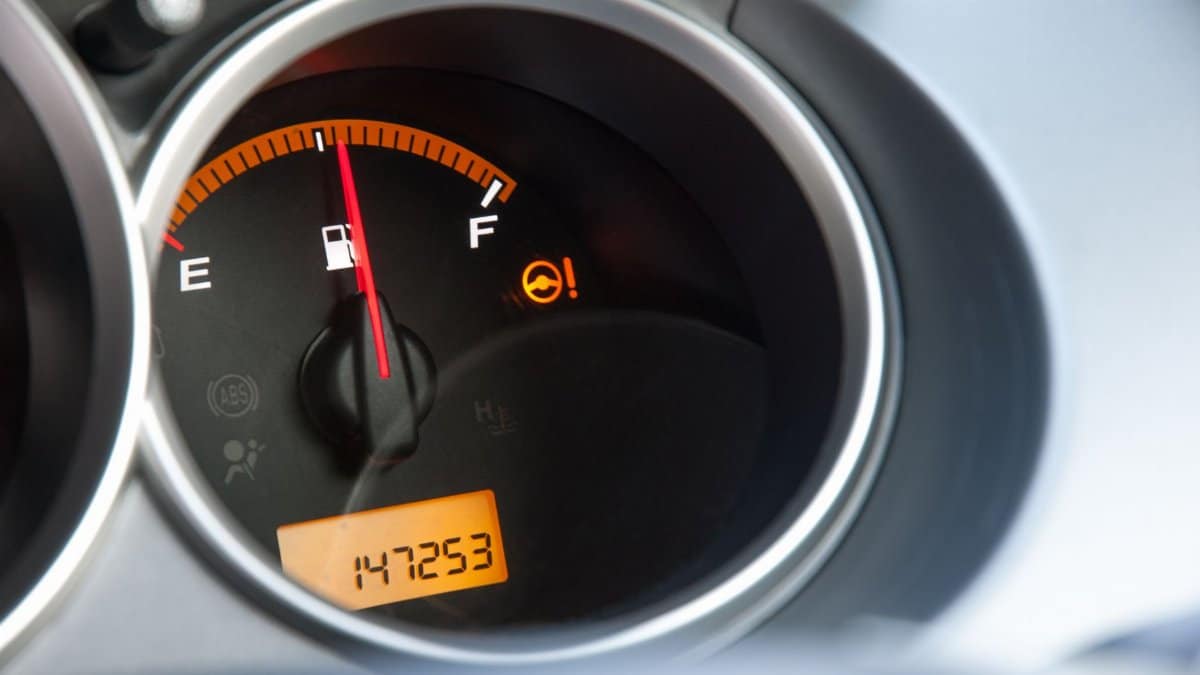 Detailed close-up of a car's fuel gauge with odometer showing a reading of 147253 miles.