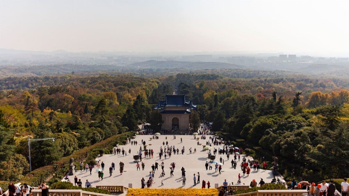 Aerial view of Sun Yat-sen Mausoleum with crowds and lush forest in Nanjing, China.